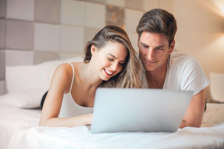 Couple watching live cam show together on laptop