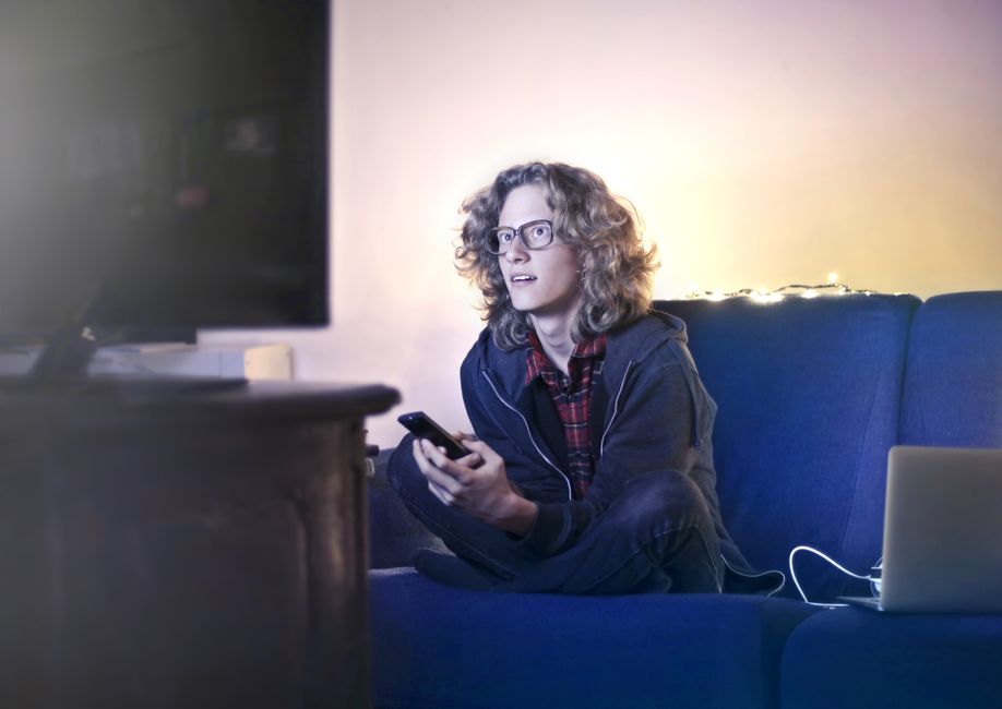 Viewer watching live cam stream on large screen in dark room