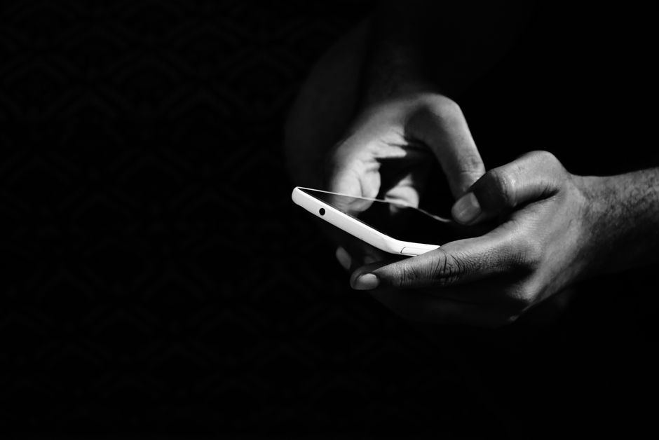 Person browsing on smartphone with dark luxury aesthetic