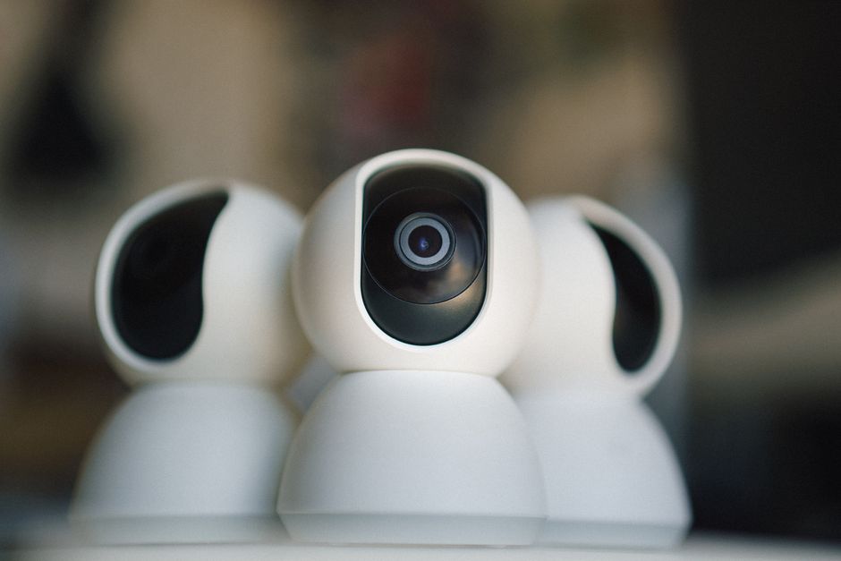 A dimly lit webcam studio with a security camera visible