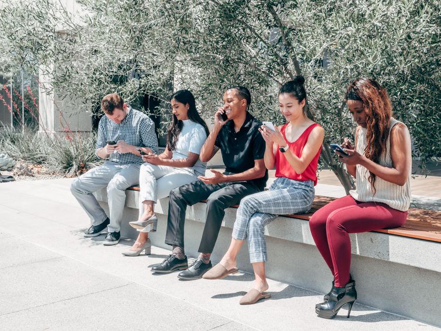 Hands holding phones showing group chat networks
