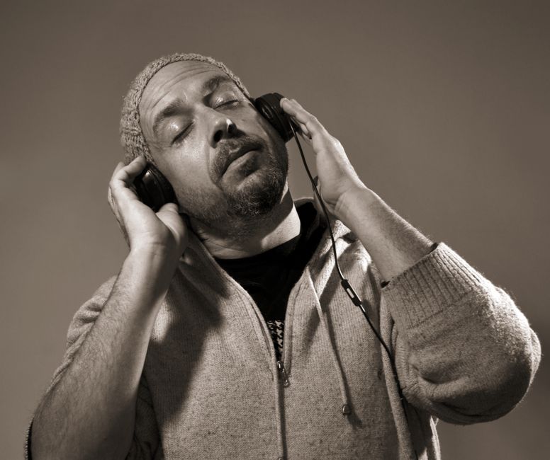 Person immersed in audio with headphones in soft neon lighting