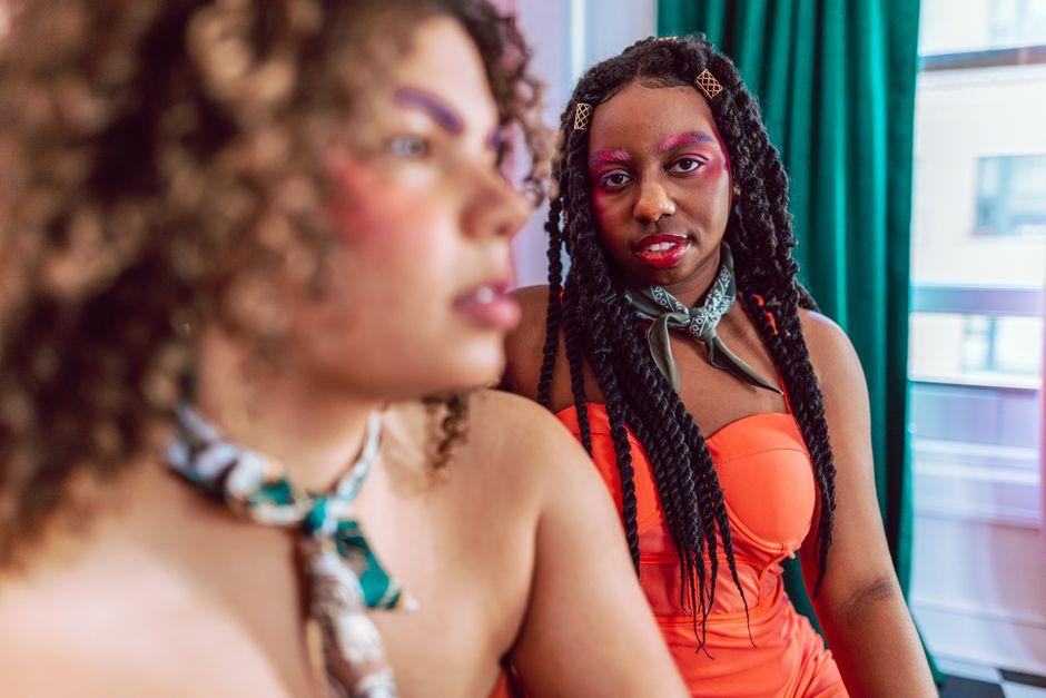 Non-binary cam performer in vibrant studio setting